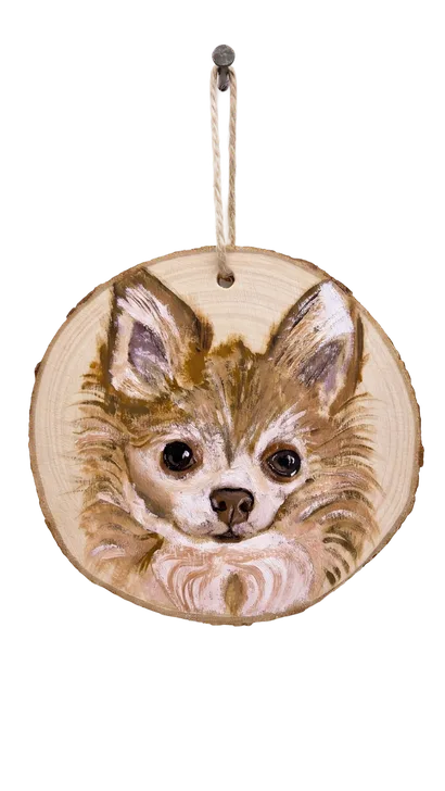 Small long-haired dog painted on a wood slice
